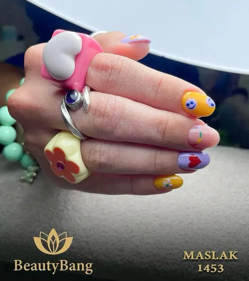 Sarı, lila ve pembe tonlarda küçük sembollü kısa tırnaklar